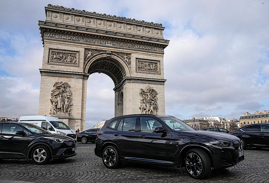 ARCHIV - SUVs fahren auf der Champs Elysee vor dem Arc de Triomphe.  