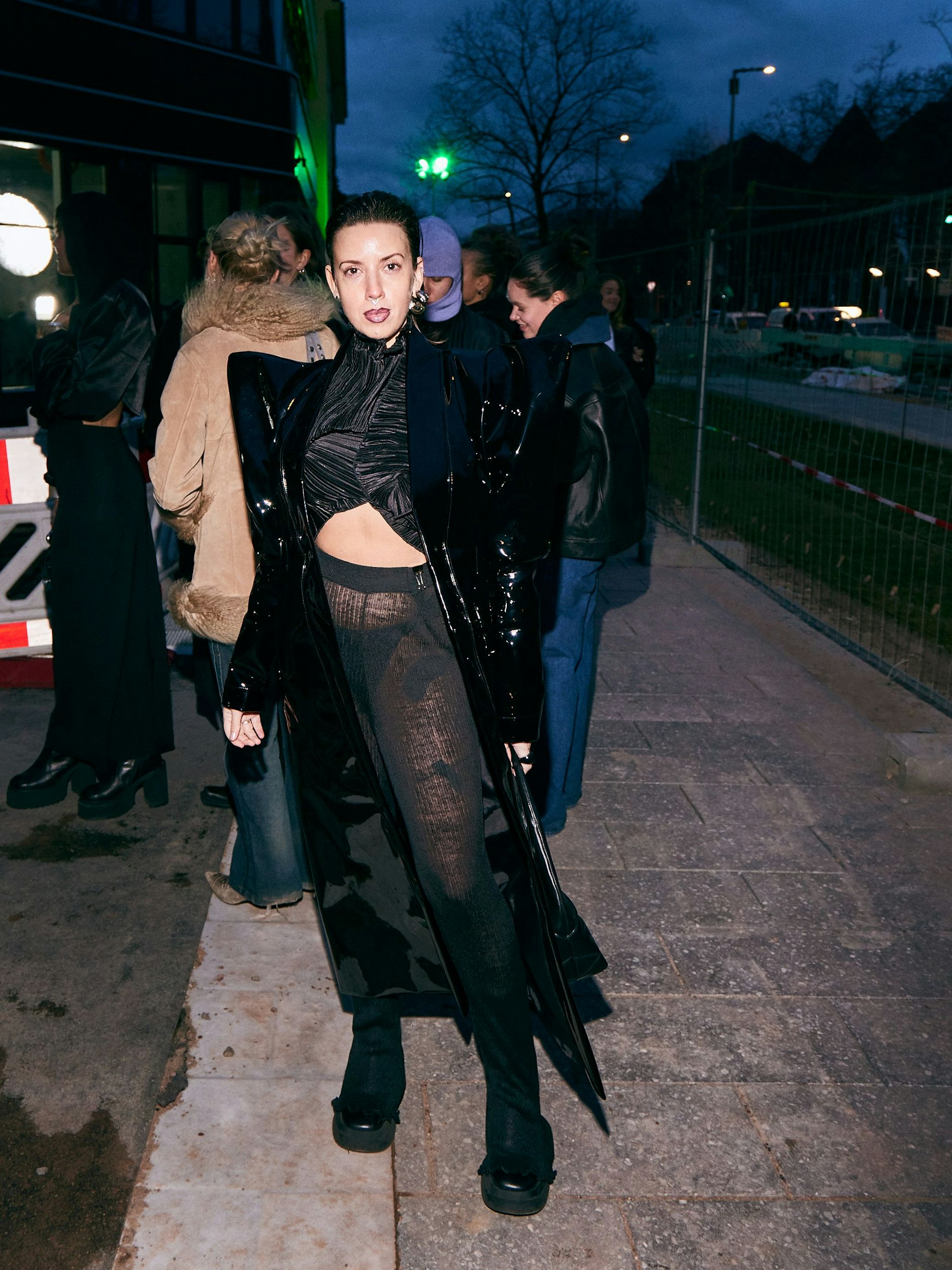 Im angesagten Strumpfhosen-Look kommt Diana nach Westend. Dazu trägt sie einen schwarzen Lackmantel mit exaltierter Schulterpartie. Instagram: <a target="_blank" rel="nofollow" href="https://www.instagram.com/deux.femmesfatales/">@deux.femmesfatales</a>