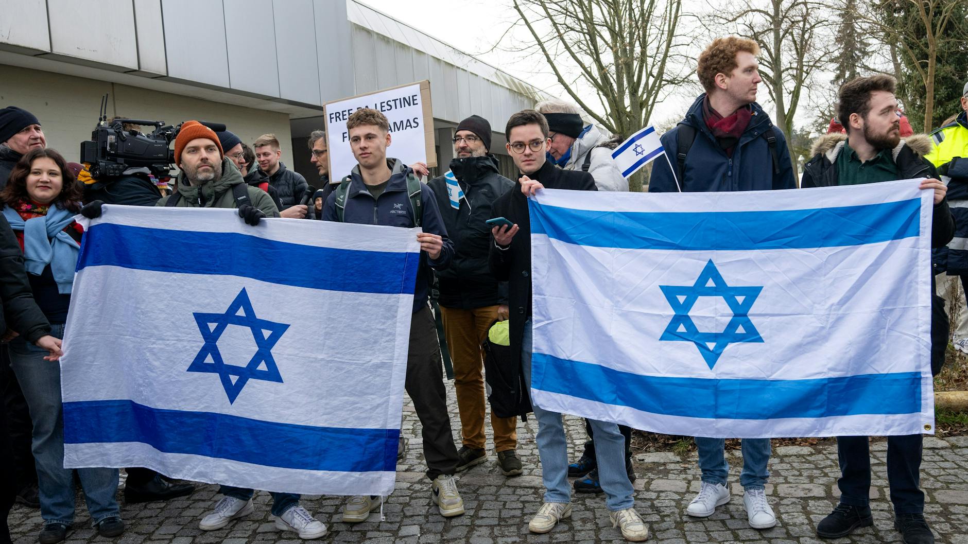 Teilnehmer einer Gegenkundgebung halten israelische Fahnen am Rande einer propalästinensischen Kundgebung.
