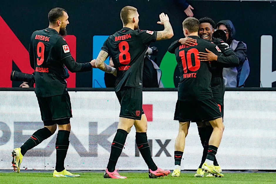 Leverkusens Torschütze Nathan Tella (r) jubelt mit seinen Mannschaftskollegen über das Tor zum 2:0.  