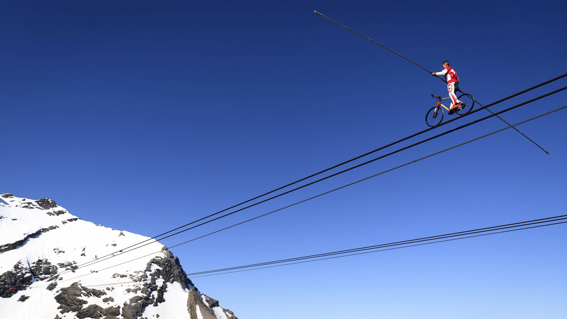 Schweiz, Ormont-Dessus: Freddy Nock fährt mit einem Spezial-Fahrrad auf dem Seil einer Seilbahn.