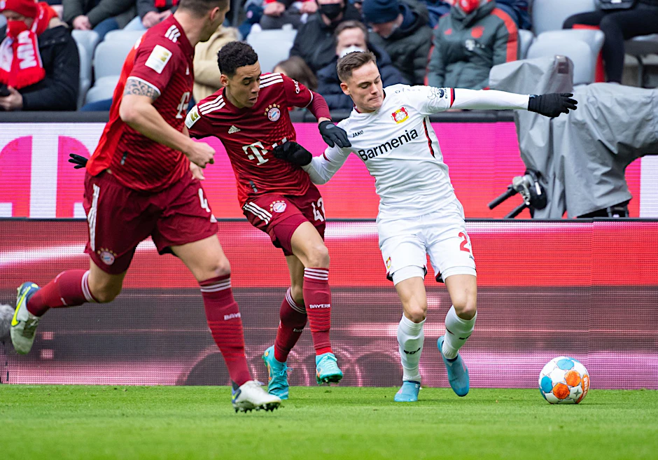 ARCHIV - Bayern Münchens Jamal Musiala (l) und der Leverkusener Florian Wirtz treffen am Samstag wieder aufeinander.  