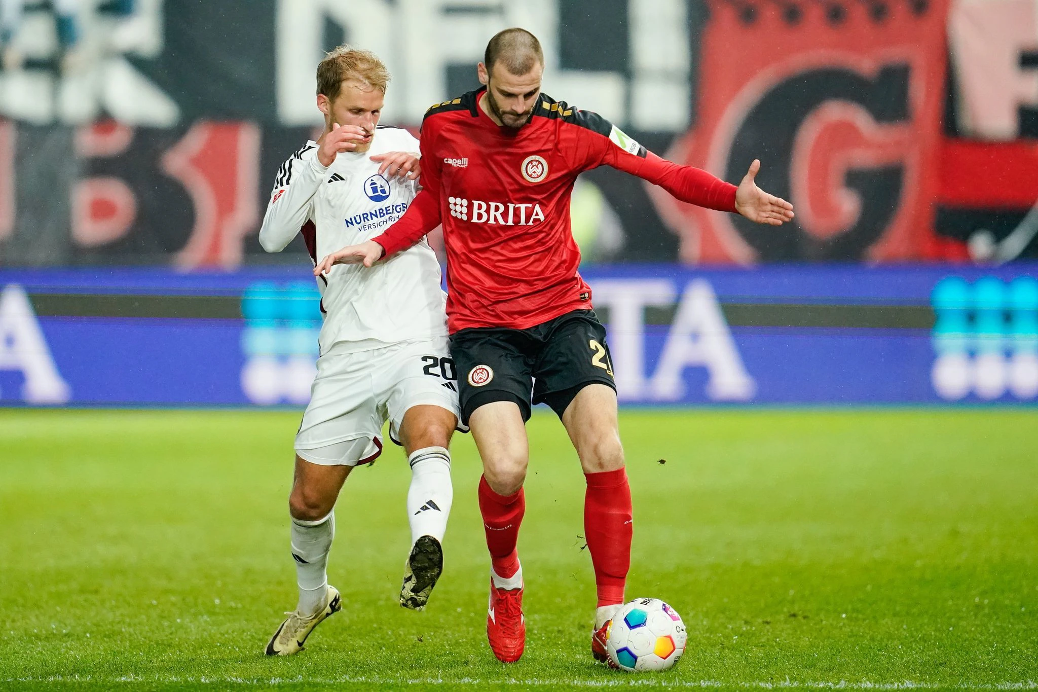 Nürnbergs Sebastian Andersson (l) und Wiesbadens Aleksandar Vukotic im Kampf um den Ball.  
