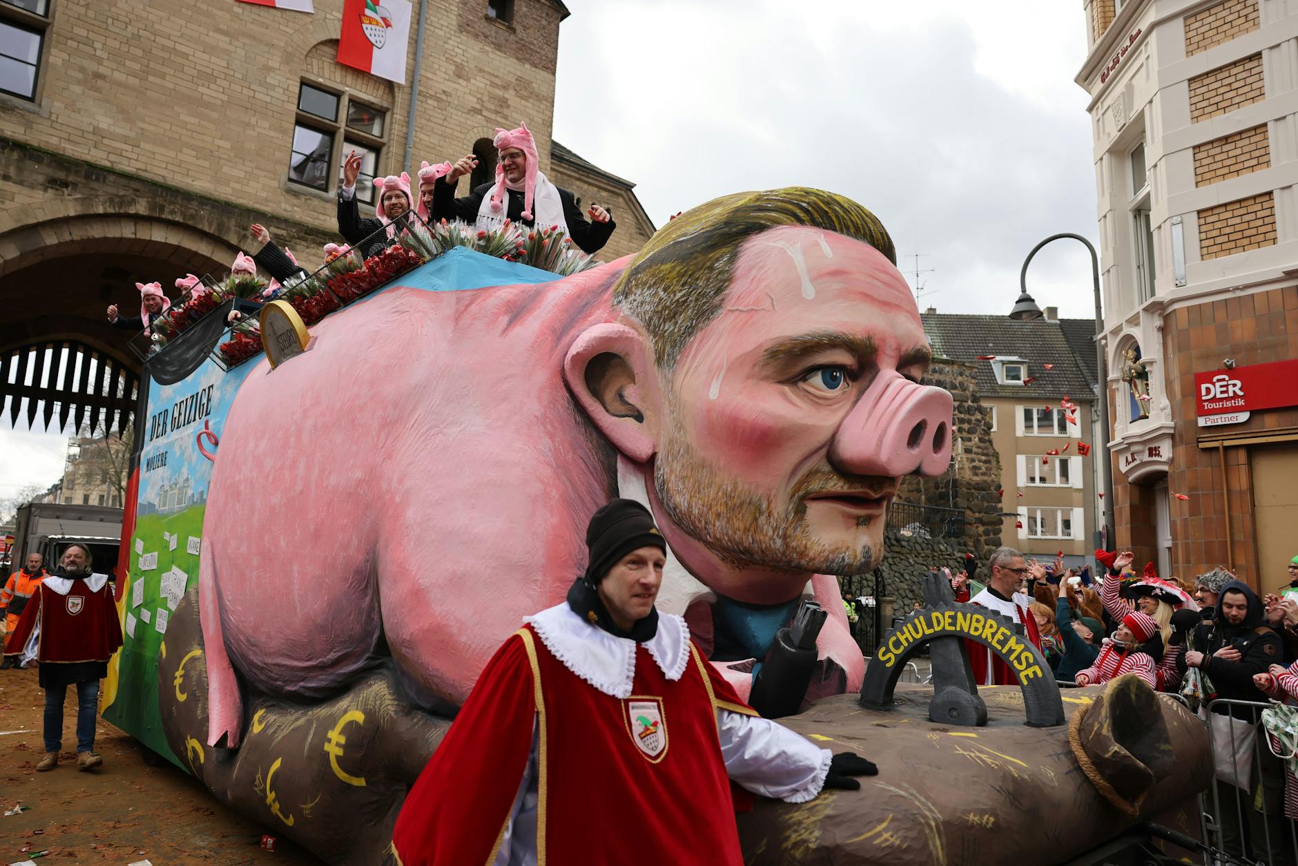 Bundesfinanzminister Christian Lindner (FDP) fährt als Sparschwein mit Schuldenbremse durch Köln.