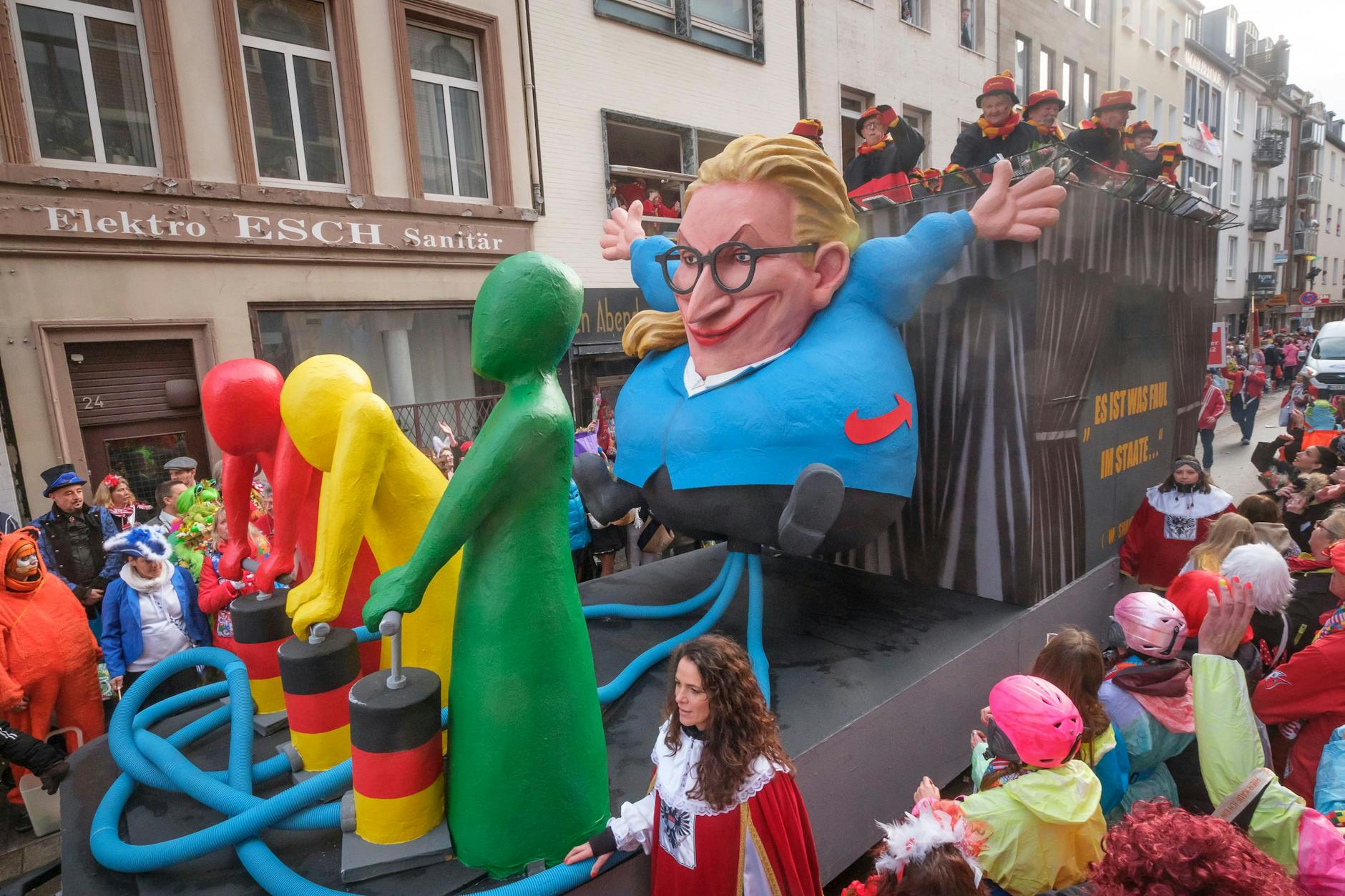 Auf einem Motivwagen in Köln pumpen die drei Parteien der Ampel-Regierung mit ihrer Politik die AfD-Bundestagsfraktionsvorsitzende Alice Weidel wie einen Ballon auf.