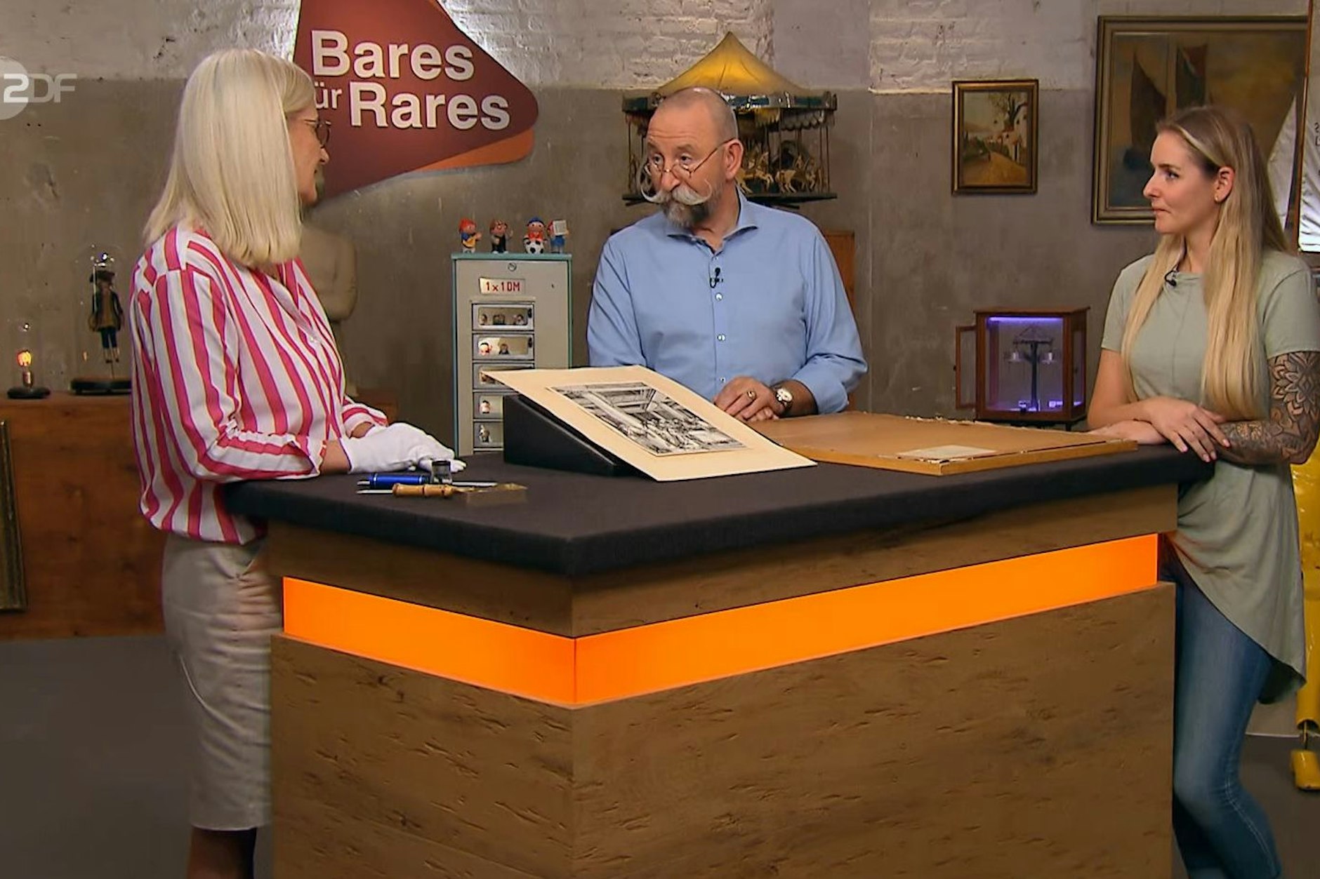 „Bares für Rares“-Moderator Horst Lichter kann kaum glauben, was er da von seiner Expertin Dr. Friederike Werner (l.) zu hören bekommt.