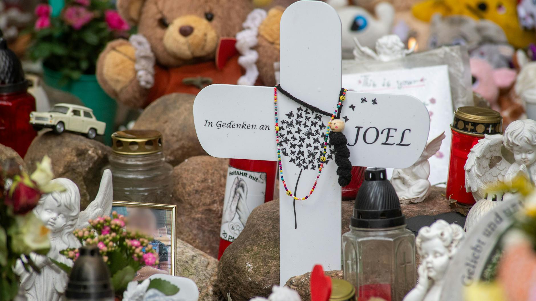 Nahe der Stelle in Pragsdorf, wo Joel (6) im September 2023 mit Stichverletzungen gefunden wurde, an denen er später verstarb, sind unter anderem Kreuze, Plüschtiere und Blumen abgelegt worden.