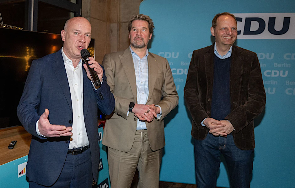 Kai Wegner (l-r, CDU), Dirk Stettner und Thomas Heilmann (CDU), stehen am Wahlabend im Kochwerk im Bezirk Pankow.  
