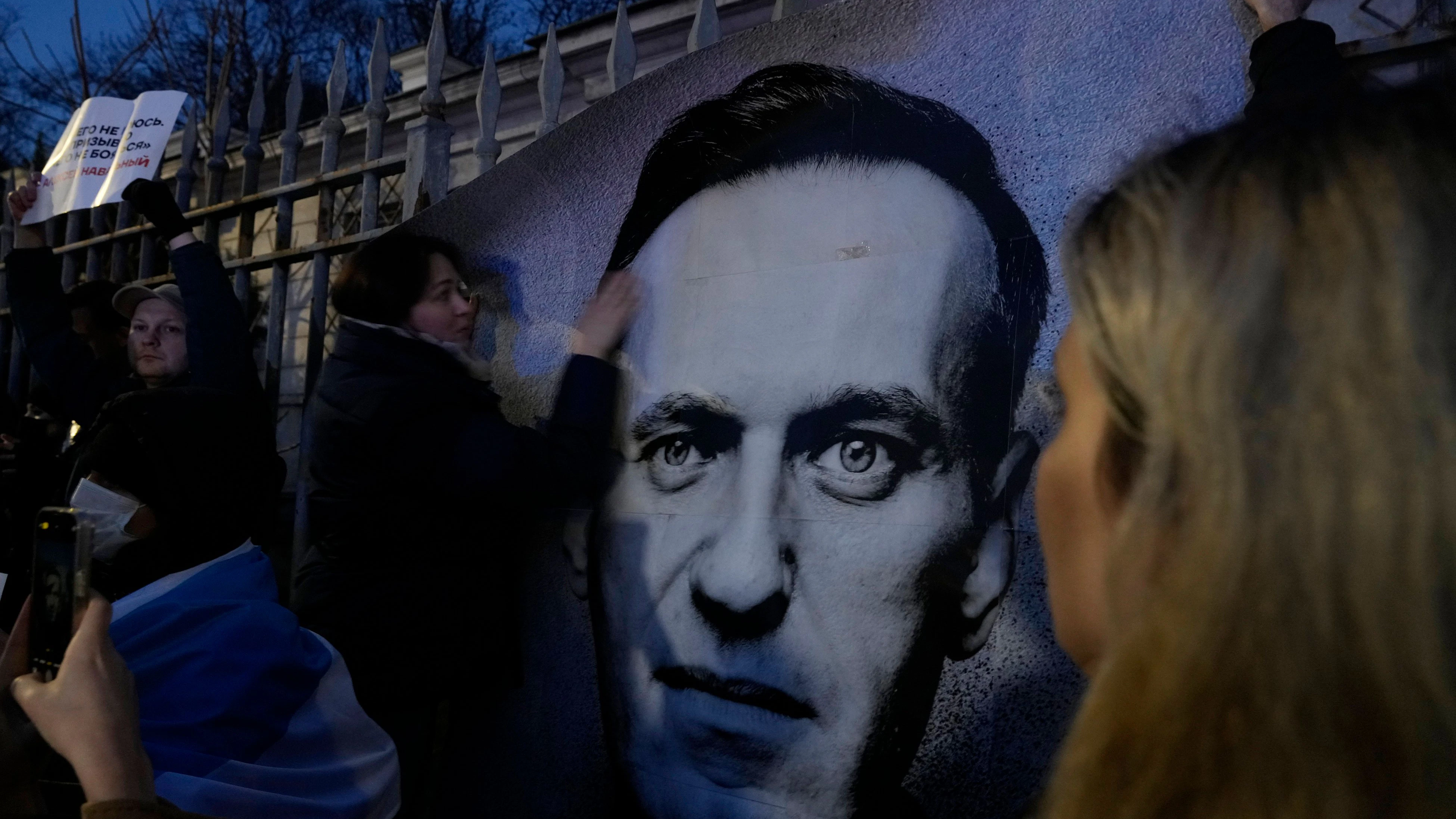 In der polnischen Hauptstadt Warschau halten Menschen ein Porträt des verstorbenen russischen Oppositionellen Nawalny während einer Trauerkundgebung vor der russischen Botschaft.&nbsp;