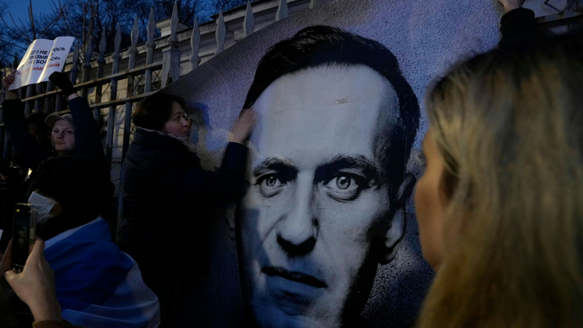 In der polnischen Hauptstadt Warschau halten Menschen ein Porträt des verstorbenen russischen Oppositionellen Nawalny während einer Trauerkundgebung vor der russischen Botschaft.&nbsp;