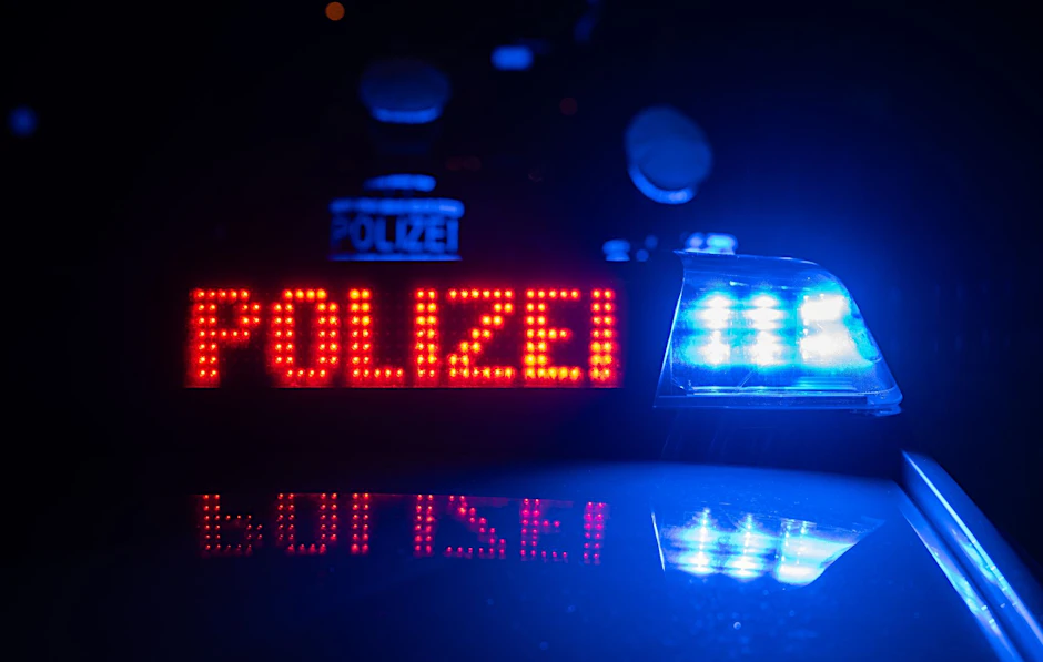 ILLUSTRATION - Zwei Polizisten stehen im Rahmen eines Fototermins vor einem Polizeifahrzeug.  