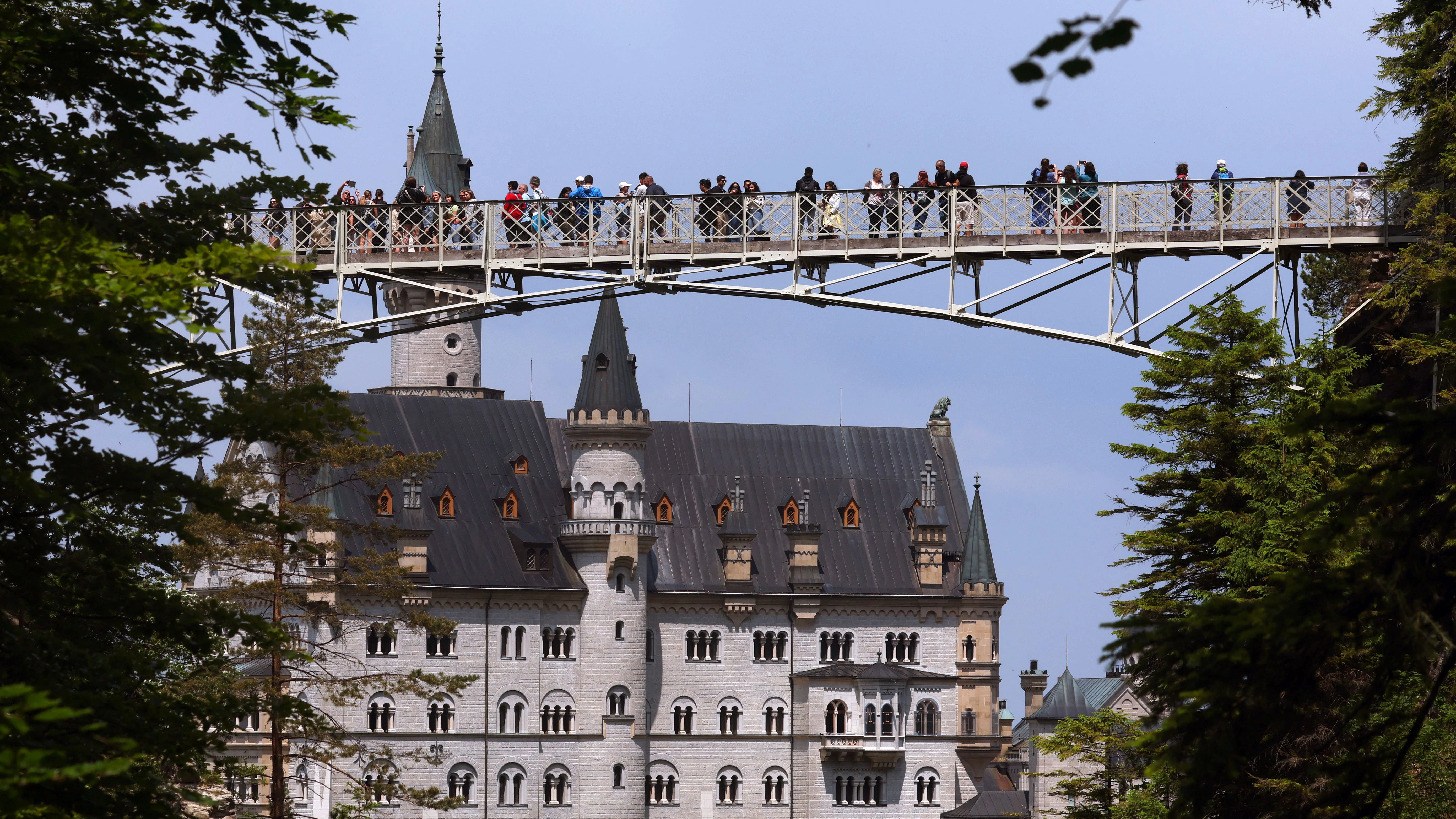 Touristen stehen auf der Marienbrücke vor dem Schloss Neuschwanstein. 