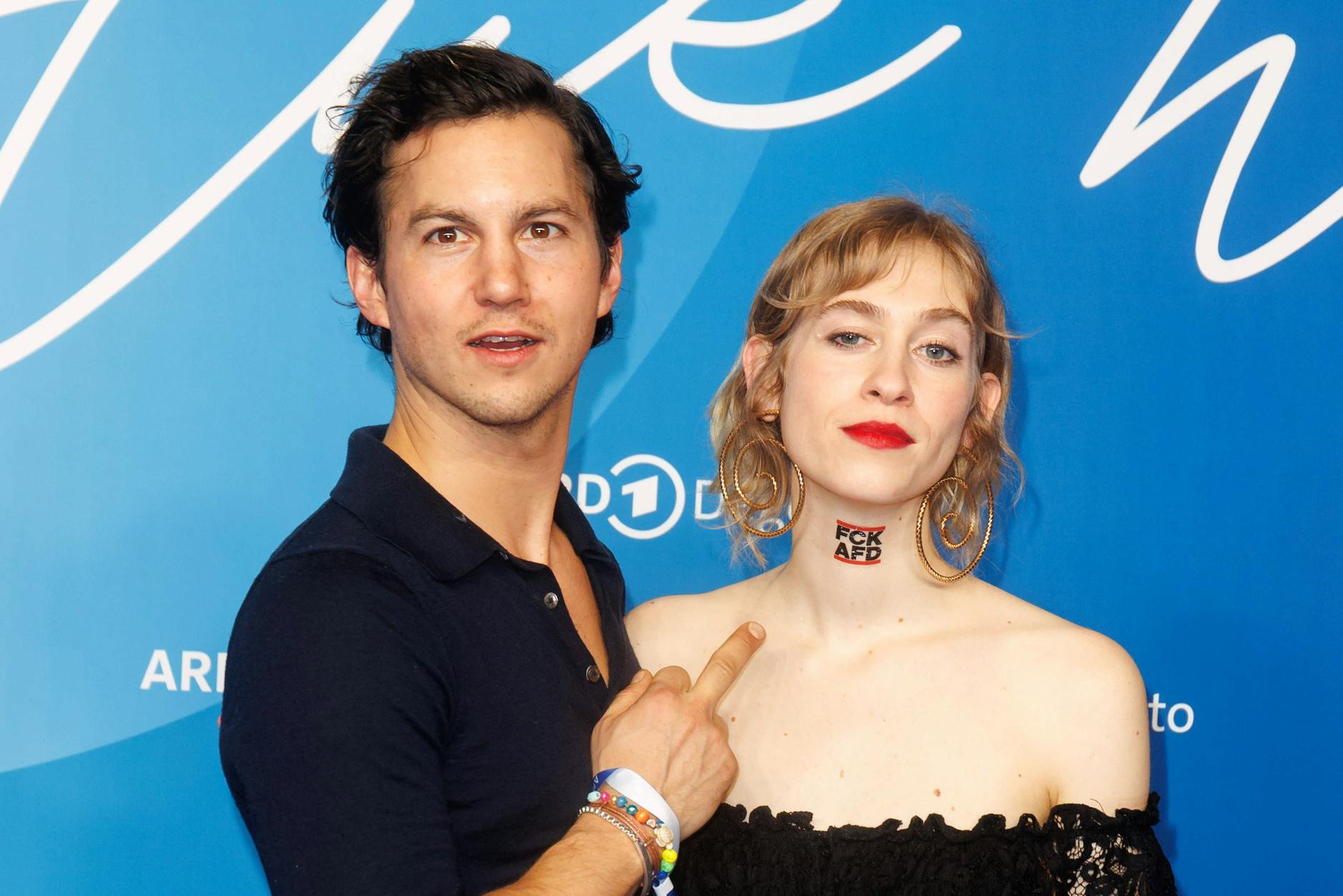 Tim Oliver Schultz und Lia von Blarer bei der ARD Blue Hour 2024. Er zeigt mit dem Mittelfinger auf ihr AfD-Tattoo.