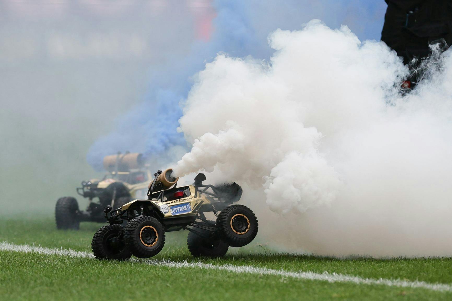 Tennisbälle oder Flummis sind schon wieder alt. Die neueste Kreation der Fans bei ihren Anti-Investoren-Protesten sind ferngesteuerte Fahrzeuge mit Rauchpatronen.