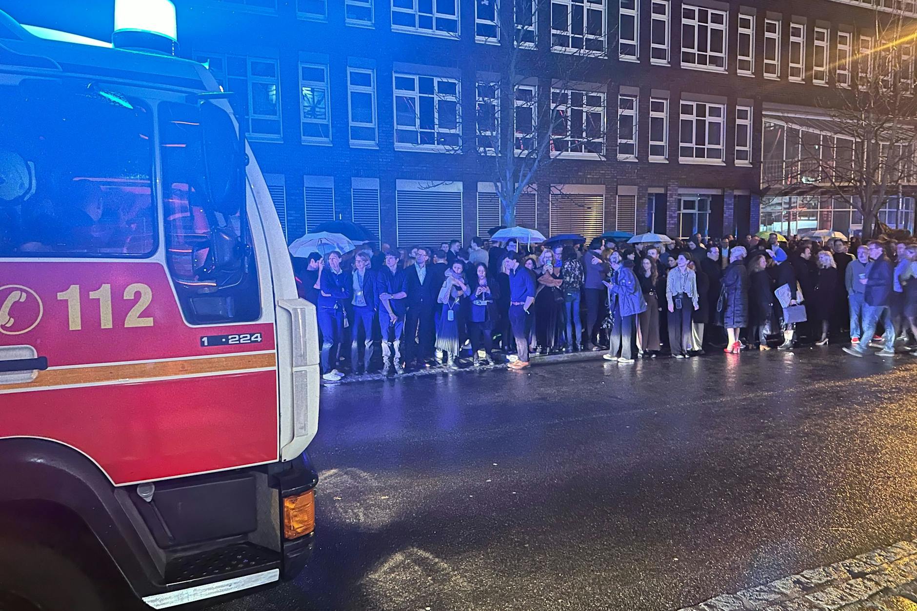 Hunderte Gäste des NRW-Empfangs im Rahmen der diesjährigen Berlinale stehen in Berlin nach einem Feueralarm im Regen.