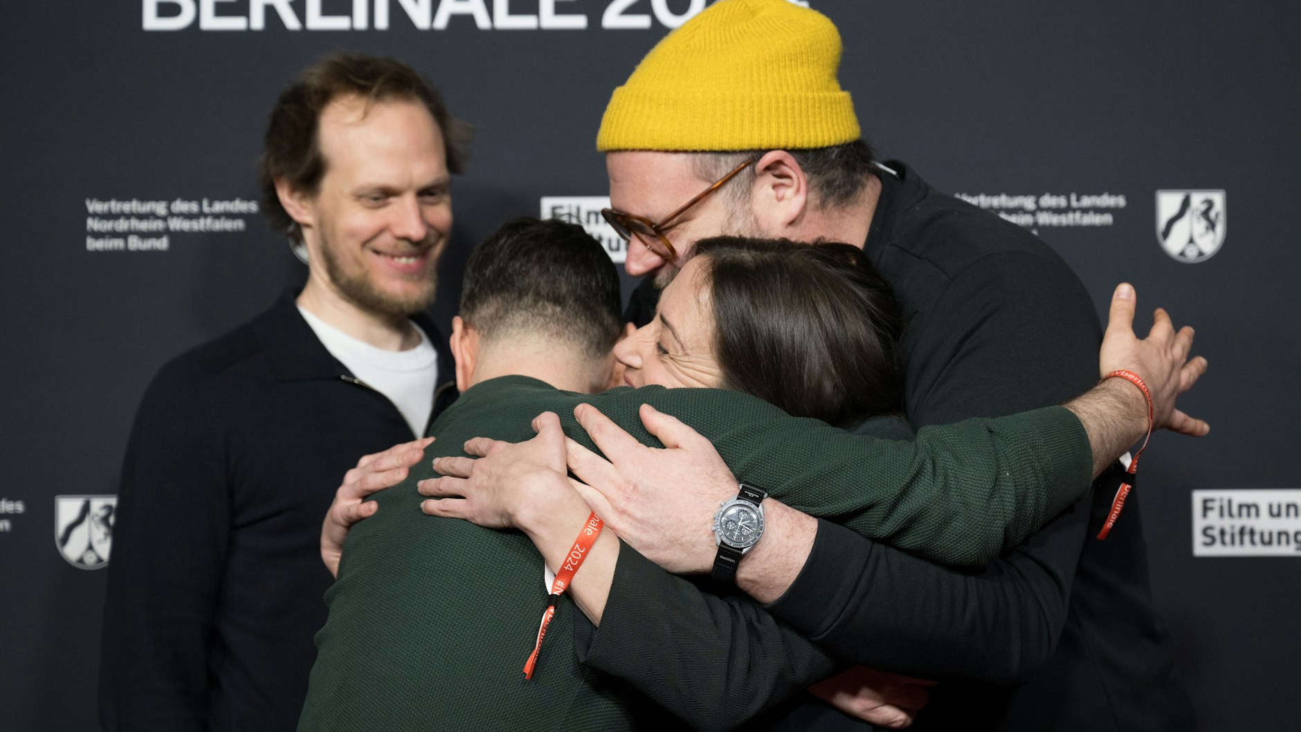 Denis Moschitto (v.l.) umarmt während des NRW-Berlinale-Empfangs die Schauspielerin&nbsp;Aenne Schwarz und den Regisseur Daniel Rakete Siegel.