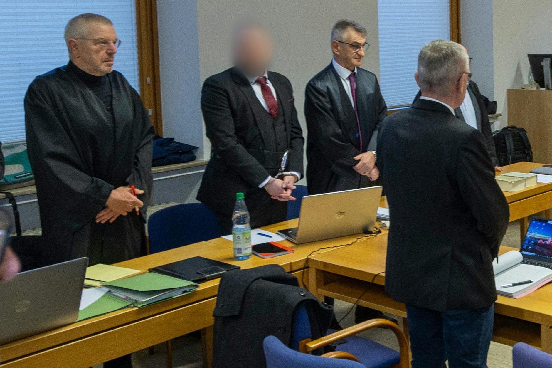 Der Angeklagte (2.v.l.) steht zum Prozessauftakt im Gerichtssaal am Landgericht Schweinfurt.