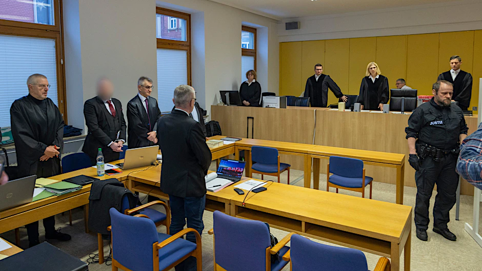 Der Angeklagte (2.v.l.) steht zum Prozessauftakt im Gerichtssaal am Landgericht Schweinfurt.