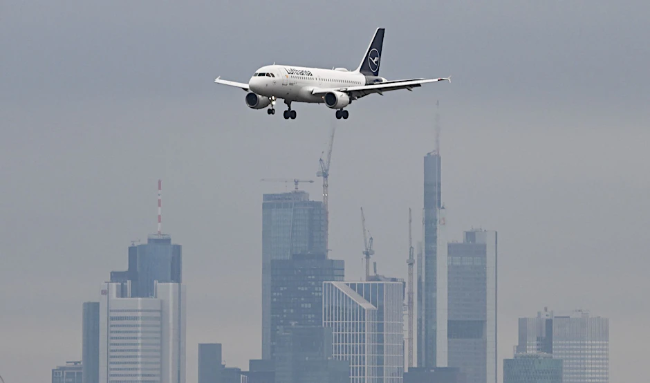 Ein Passagierflugzeug der Lufthansa ist vor der Frankfurter Skyline im Landeanflug auf den Frankfurter Flughafen.  