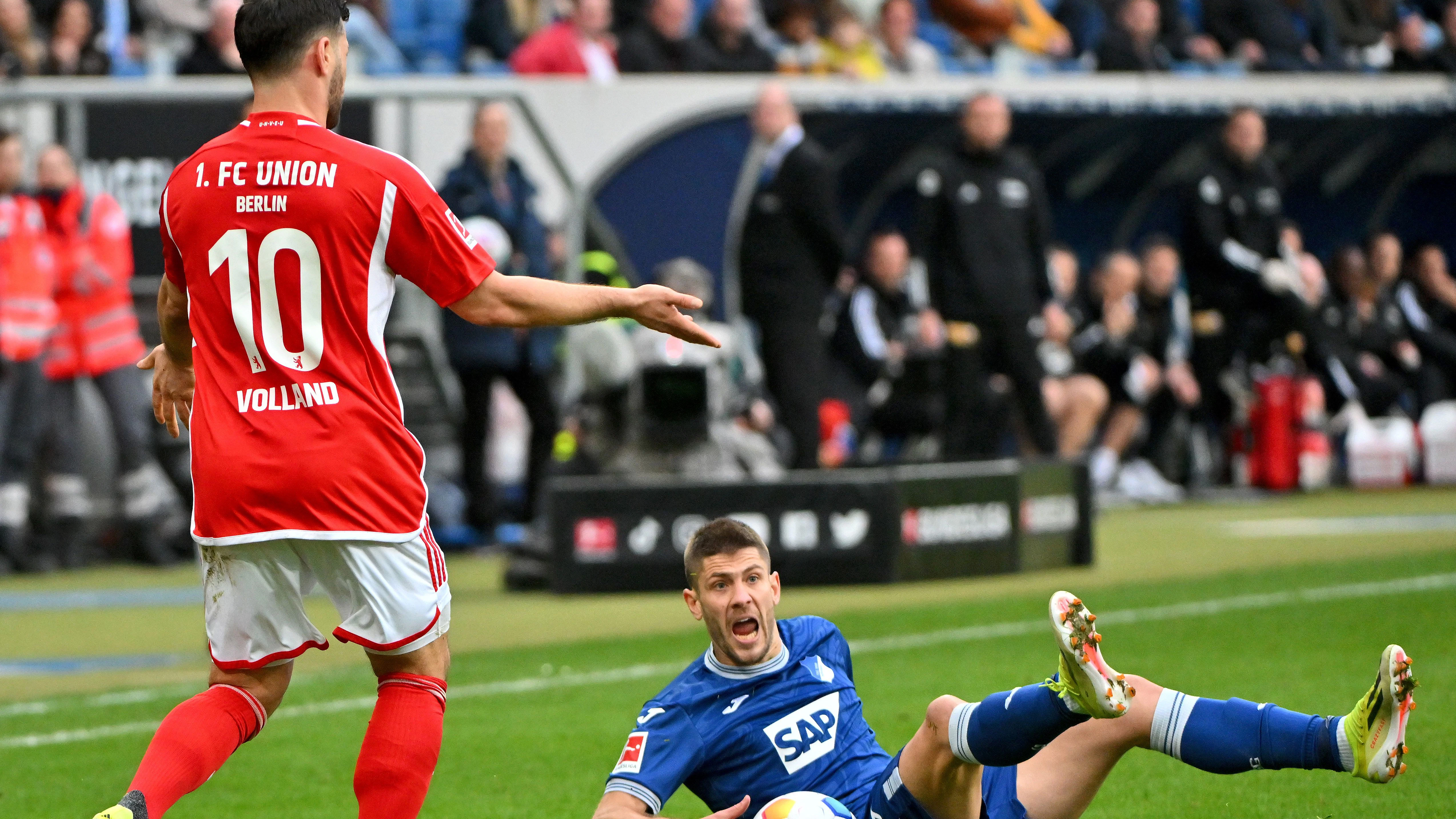 Nach einem normalen Zweikampf macht Hoffenheims Andrej Kramaric auf dem Rasen ganz viel Alarm, damit Kevin Volland maximal Ärger bekommt.