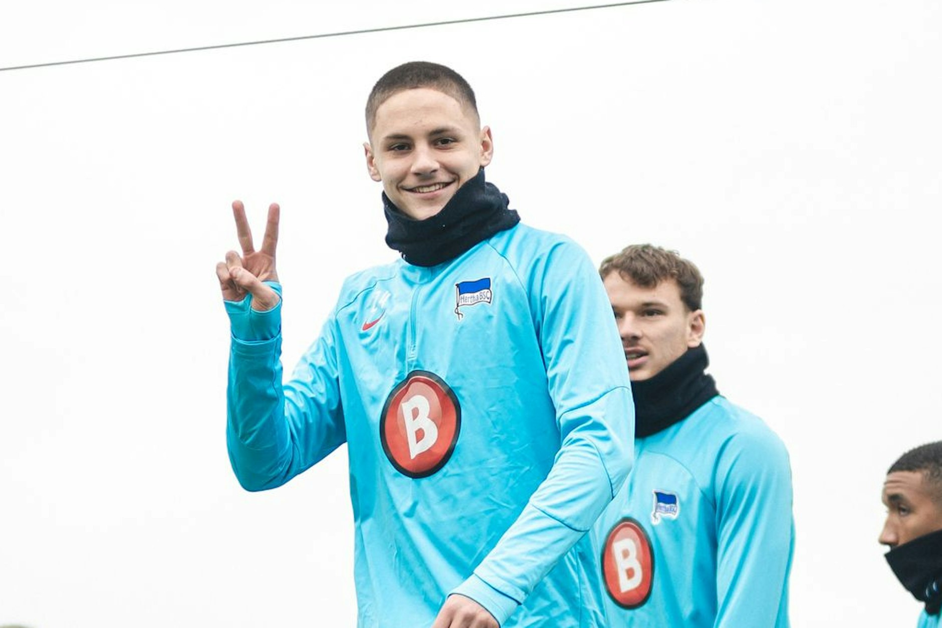 Bence Dardai betritt voller Vorfreude Herthas Trainingsplatz, zeigt das Victory-Zeichen und kann erstmals wieder komplett alles mitmachen.