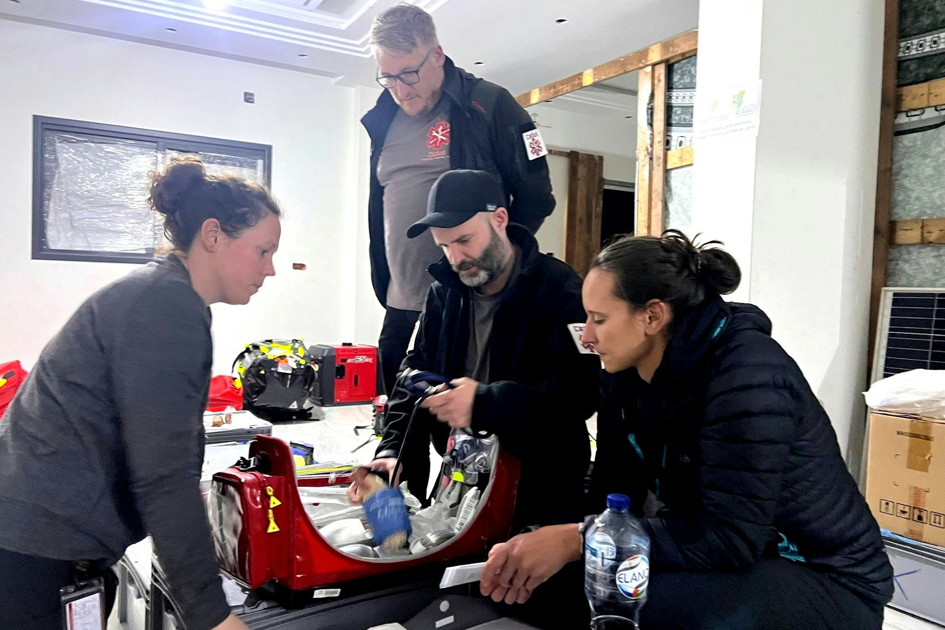 Sebastian Jünemann, Leiter der Berliner Hilfsorganisation Cadus (stehend), und sein Team packen einen Rettungsrucksack für den nächsten Einsatz.&nbsp;