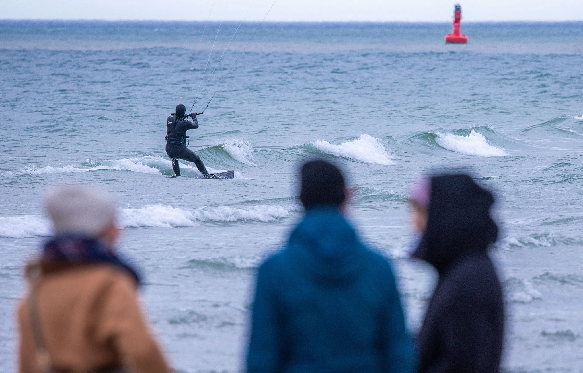 Meteorologen erwarten für die Ostseeküste starken Wind mit Sturmböen - dieser Kitesurfer scheint die aktuelle Wetterlage am Strand von Warnemünde zu genießen.  