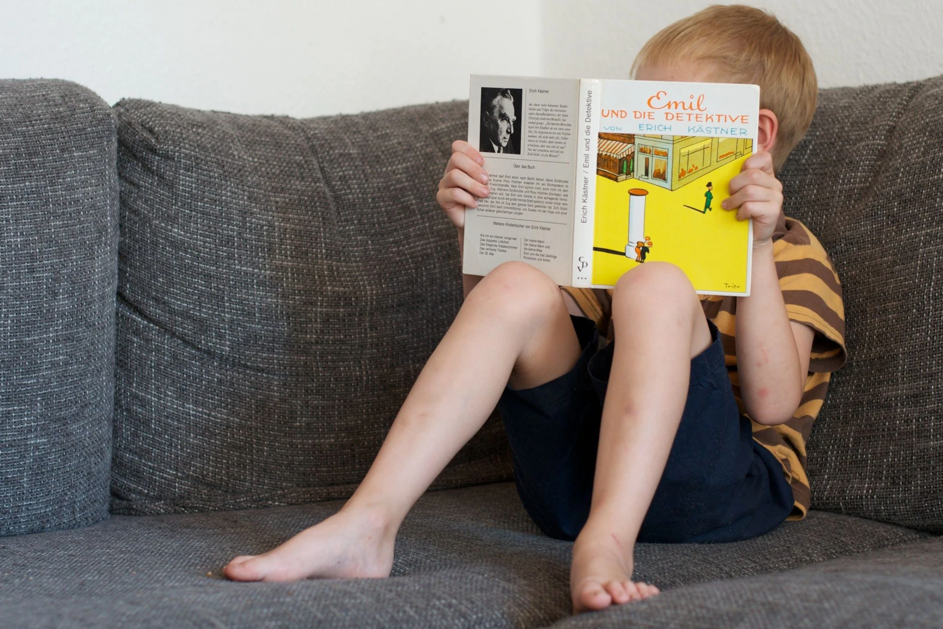 Erich Kästner lebt! Ein Junge liest „Emil und die Detektive“, einen seiner Romane für Kinder. Ein Krimi aus dem Berlin Ende der 1920er, weltweit beliebt.
