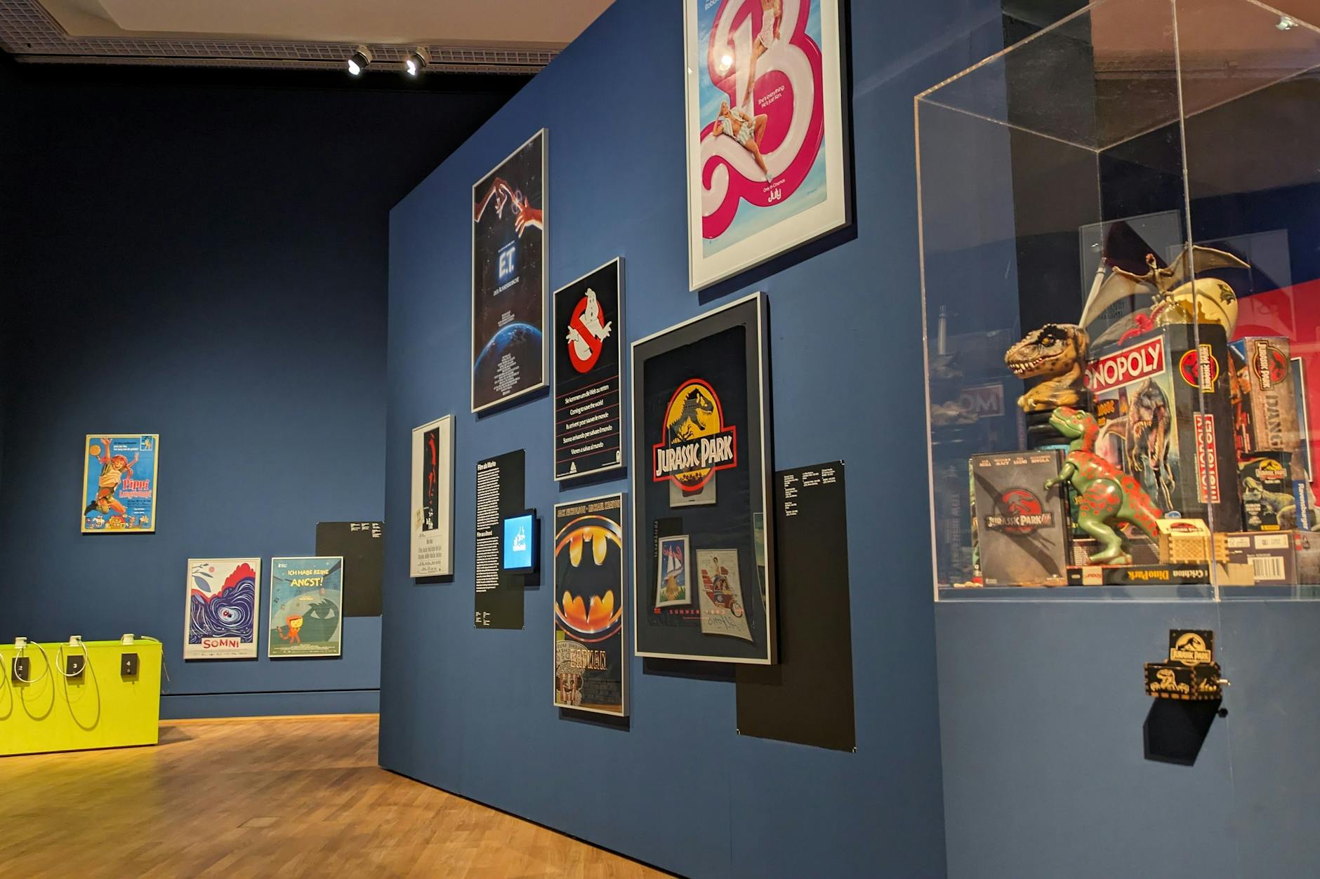 Rechts im Bild sieht man die kleine Leier, mit der man die Musik von „Jurassic Park“ anstimmen kann. Hinten links sind Hörstationen für Kinder.