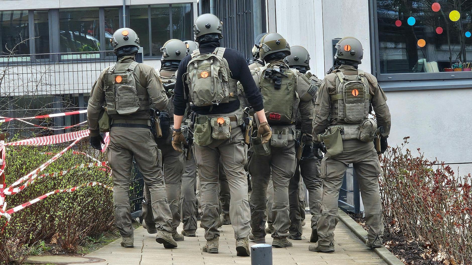 Bewaffnete Spezialkräfte der Polizei sind an dem Wuppertaler Gymnasium im Einsatz, darunter auch Beamte mit Maschinenpistolen.