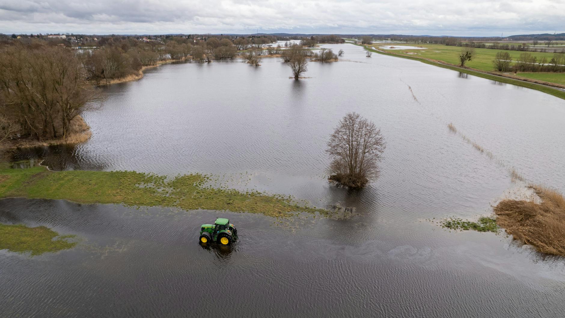 Landwirt Peter de Vries fährt mit seinem Traktor über seine überfluteten Felder.