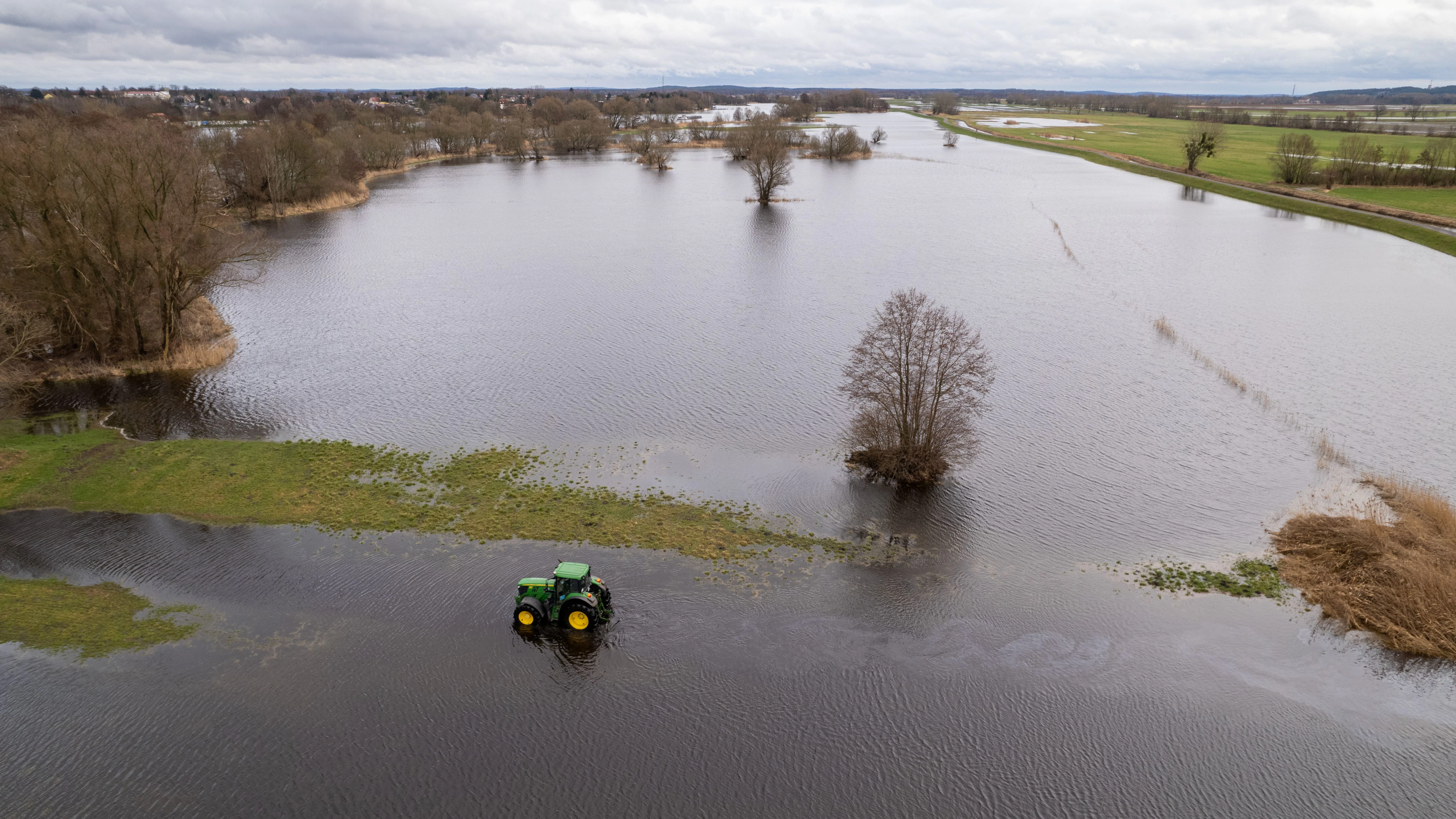 Landwirt Peter de Vries fährt mit seinem Traktor über seine überfluteten Felder.