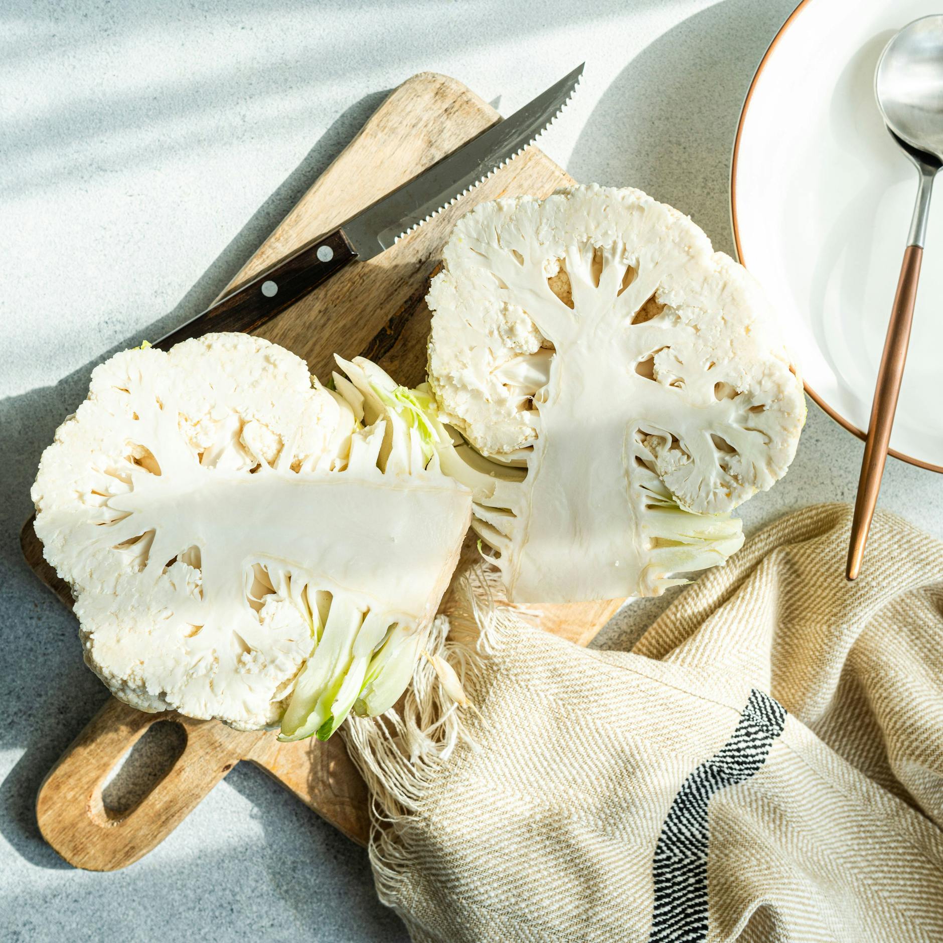 Der gewaschene Blumenkohl wird halbiert und dann in Röschen geteilt.