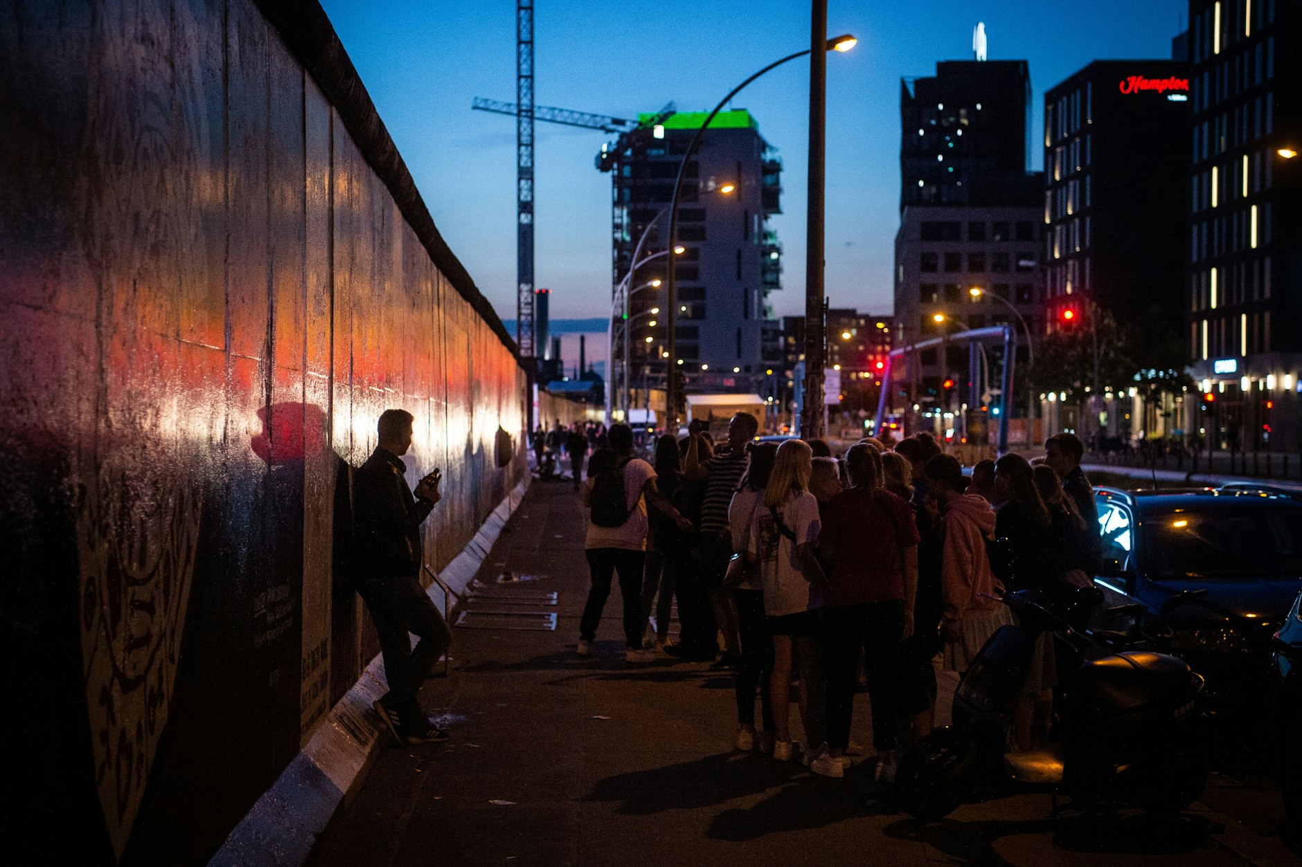Touristen und Besucher stehen vor dem sogenannten Bruderkussgemälde an der East Side Gallery. Tourismus ist die wichtigste Einnahmequelle für Berlin.