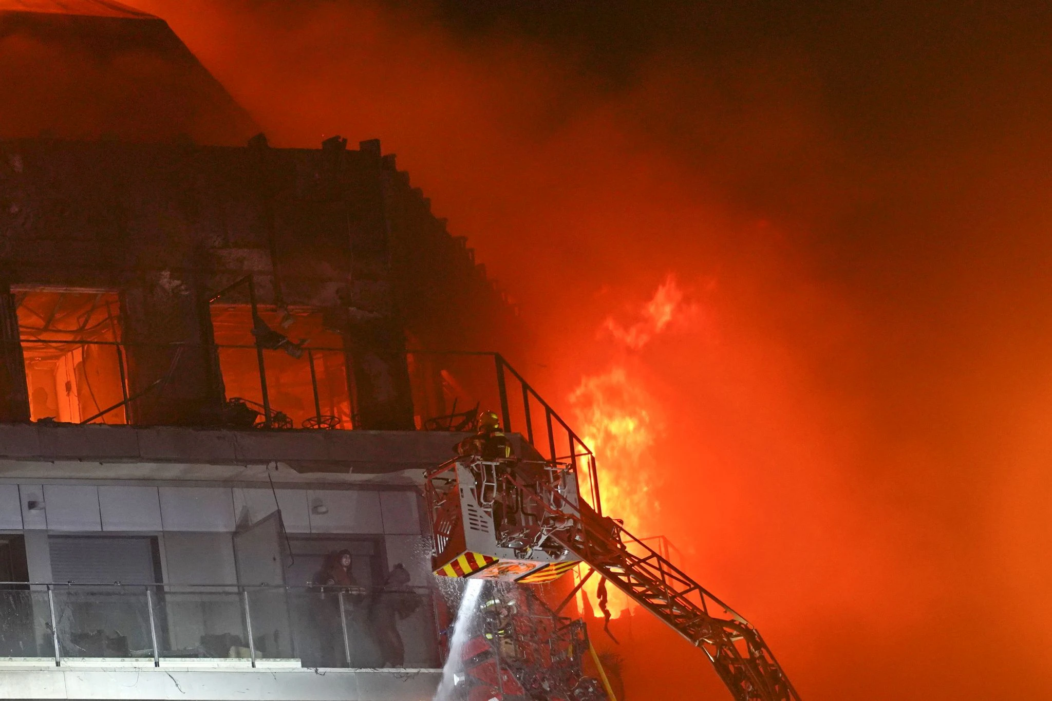 Feuerwehrleute retten zwei Menschen aus dem brennenden Hochhaus.  