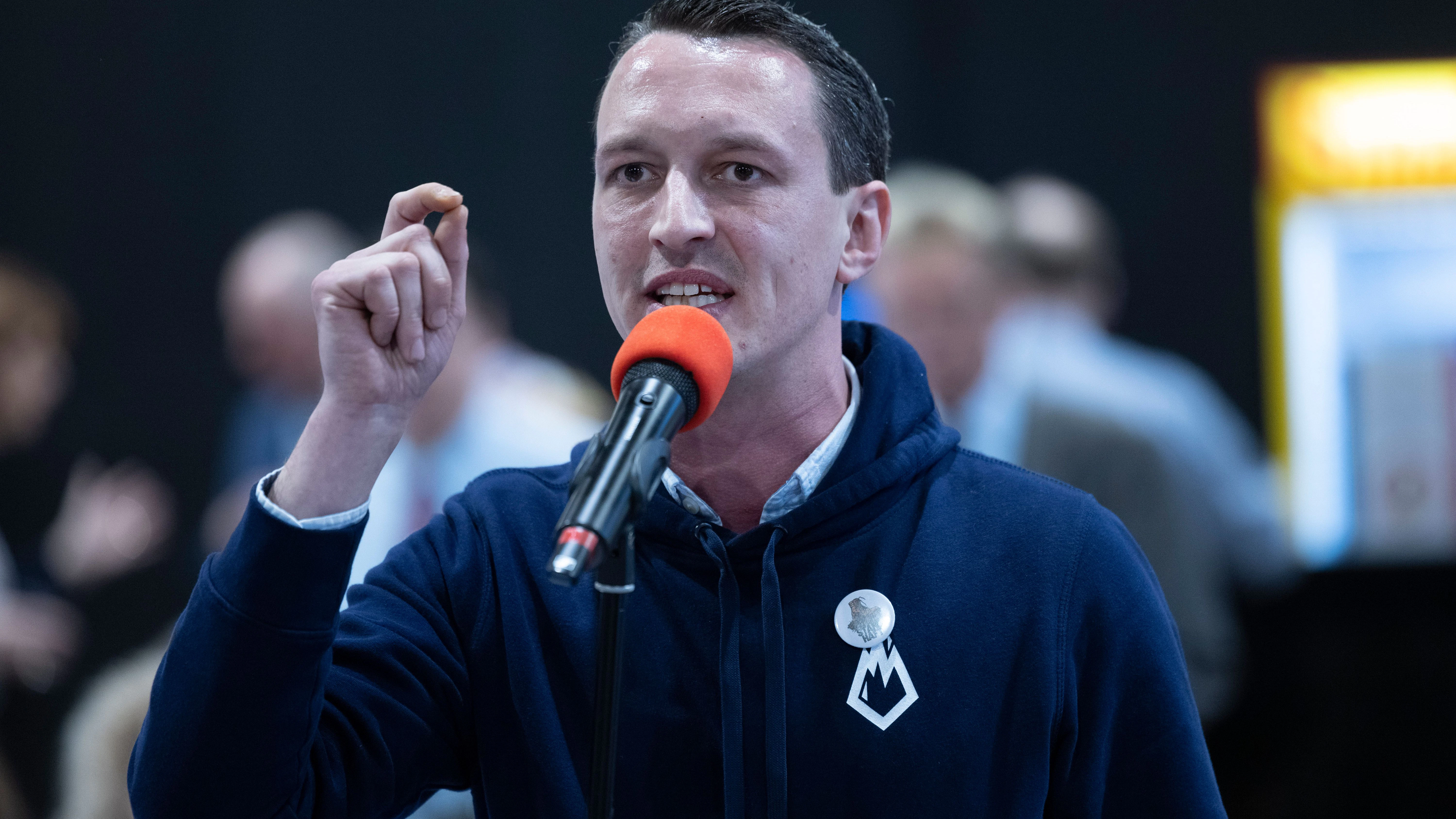 Der Bundestagsabgeordnete Matthias Helferich wurde zwar aus der AfD-Fraktion ausgeschlossen, ist aber weiter Mitglied der Partei. Beim Parteitag des NRW-Landesverbandes trug er am Wochenende einen Pulli des als gesichert rechtsextremistisch eingestuften Jugendverbandes Junge Alternative. In einem Chat bezeichnete er sich einst als „freundliches Gesicht des NS“.