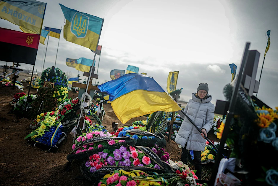 Eine Angehörige steht auf einem Friedhof in der ukrainischen Hafenstadt Odessa. Die Gräber gefallener ukrainischer Soldaten sind an den Fahnen zu erkennen. 