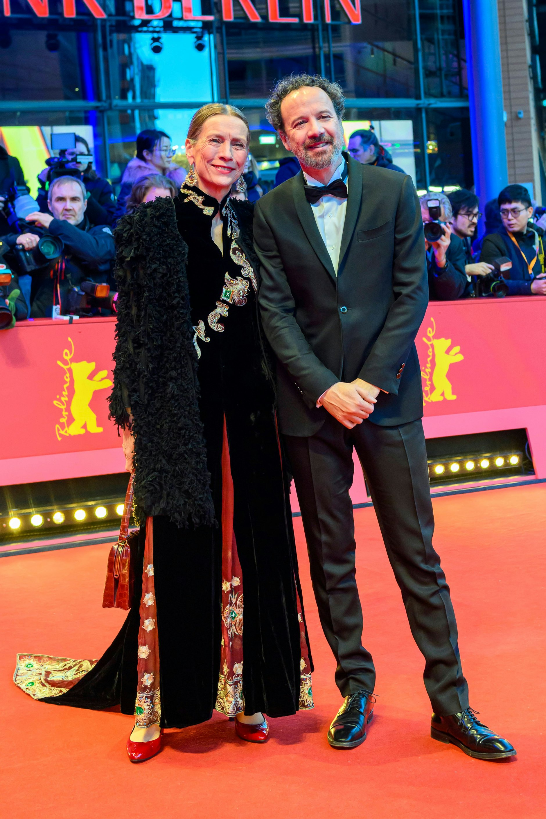 <strong>TOP:</strong> Glitzernde Ethno-Schnörkeleien, schwere Chandelier-Ohrringe, eine fluffige Oberjacke – ganz schön viel los im Outfit von <strong>Mariette Rissenbeek</strong>. Doch die Filmproduzentin bringt’s irgendwie rüber, trägt all den flitterigen Firlefanz mit Anmut und Würde; Chapeau für diesen originellen Auftritt. Und: Der italienische Filmkritiker <strong>Carlo Chatrian</strong> macht sich im perfekt geschnittenen Anzug als Begleiter ausgesprochen gut.