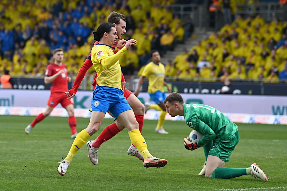 Berlins Torwart Tjark Ernst (r) spielt gegen Braunschweigs Rayan Philippe und Berlins Pascal Klemens.  