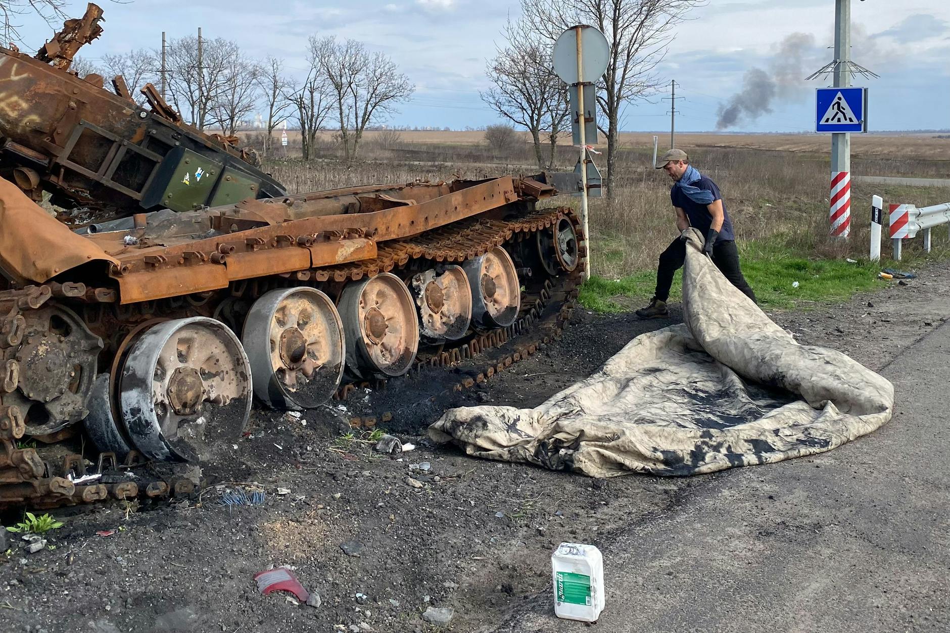 Der Künstler Fabian Knecht in der Ukraine mit einer Leinwand, die er durch einen Panzer gezogen hat.