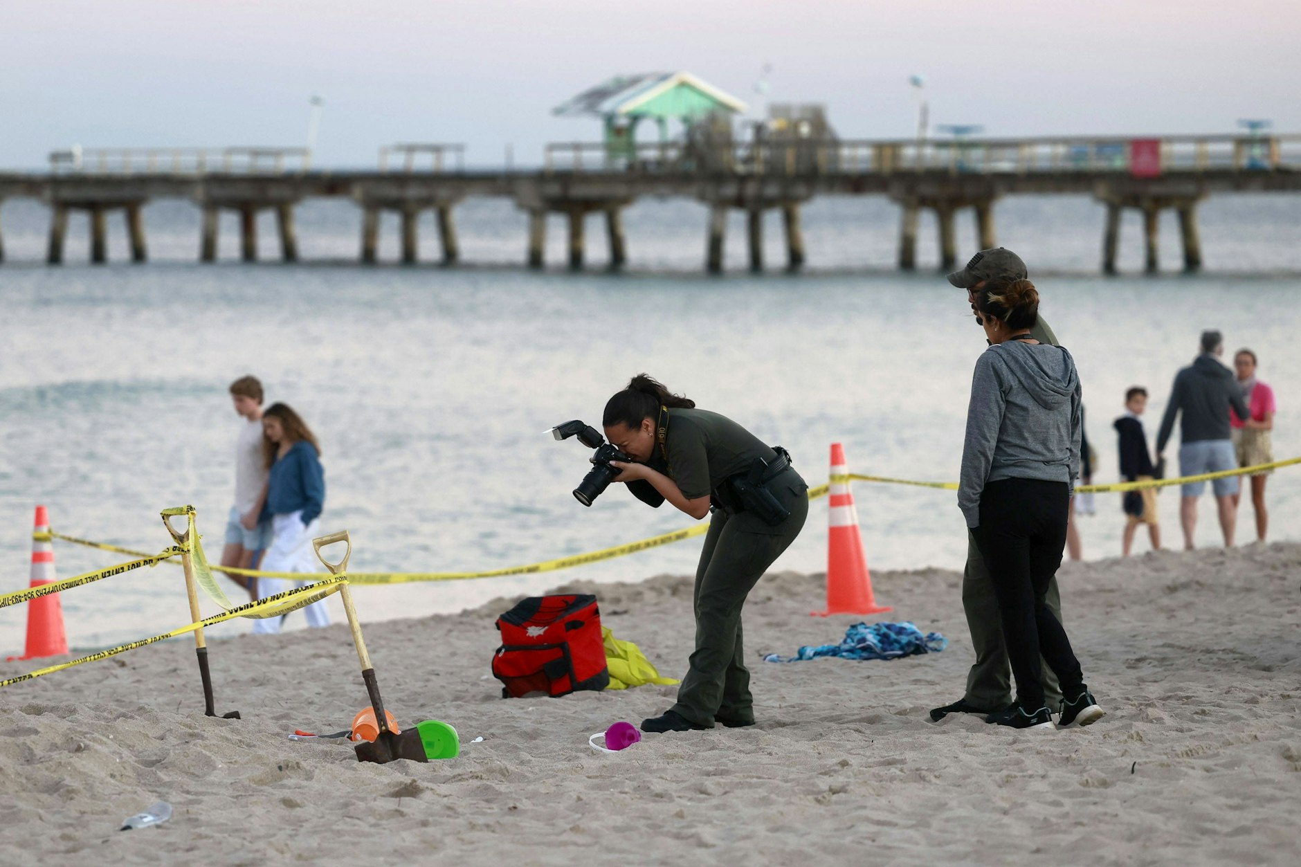 Ermittler fotografieren den Unglücksort, an dem das kleine Mädchen im Sand verschüttet wurde.