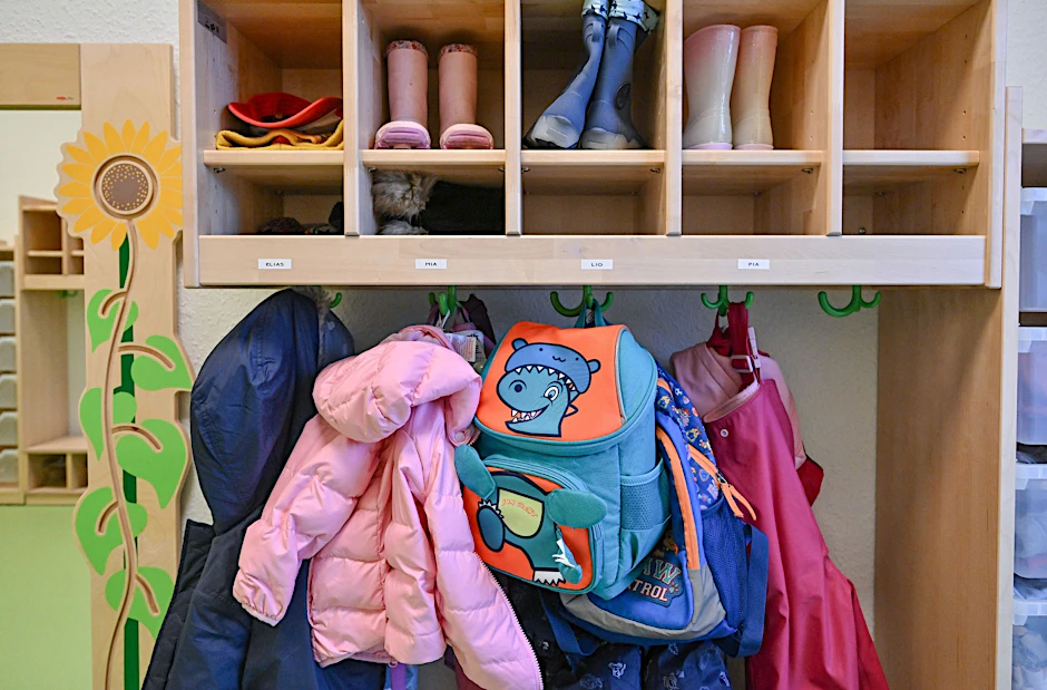 ARCHIV - Kleidung von Kindern hängt in einer Kita / Kindergarten.  