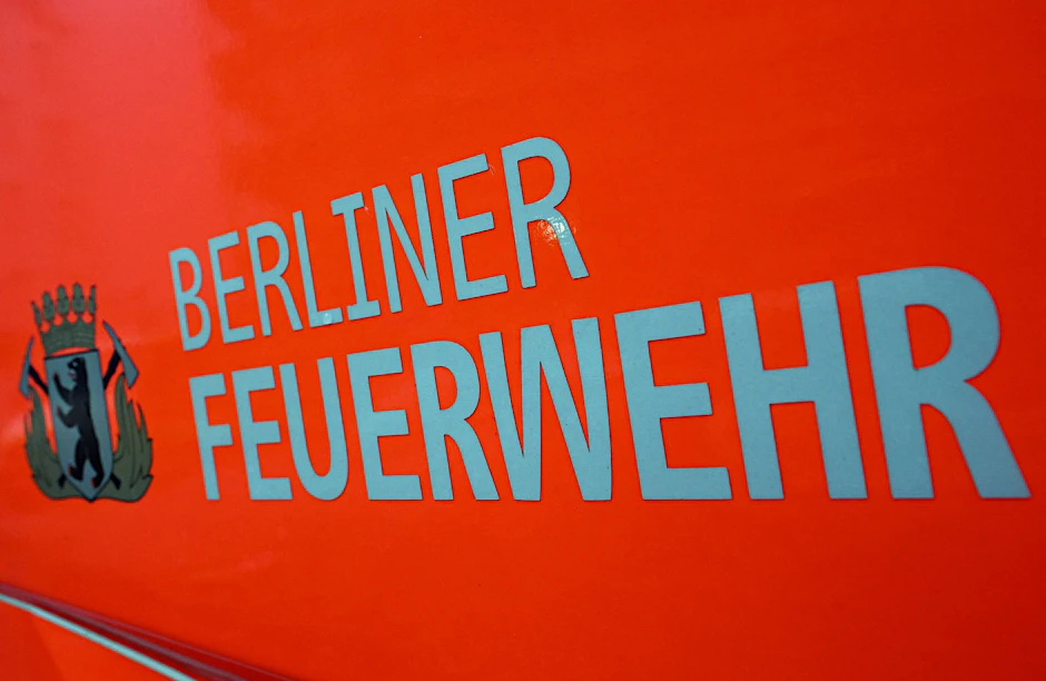 ARCHIV - Der Schriftzug "Berliner Feuerwehr" und das Wappen Berliner Feuerwehr mit dem Berliner Bären stehen auf der Tür eines Feuerwehrfahrzeuges.  