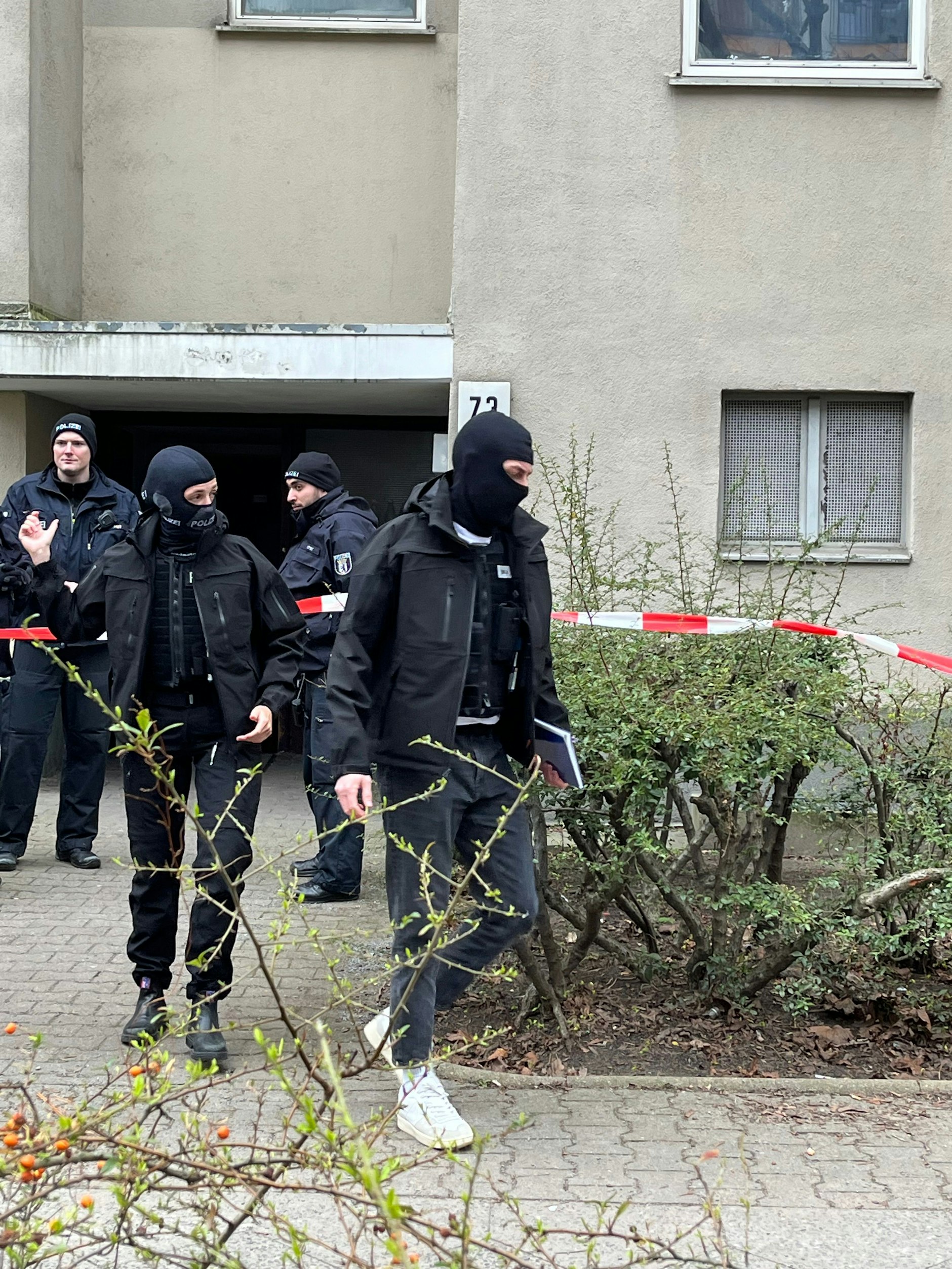 Vermummte Polizisten verlassen das Wohnhaus in Kreuzberg, in dem Klette zuletzt lebte.