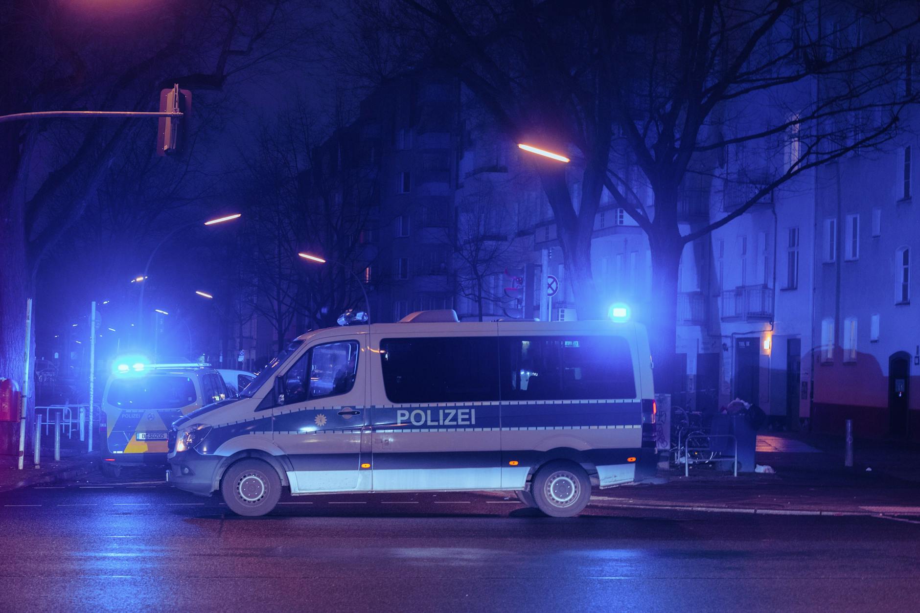 Mehrere Einsatzwagen der Berliner Polizei stehen auf einer Straße. 