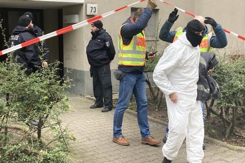 Polizisten und Kriminaltechnik vor dem Wohnhaus