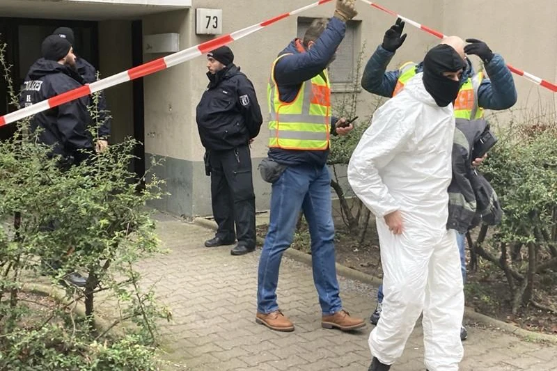 Polizisten und Kriminaltechnik vor dem Wohnhaus