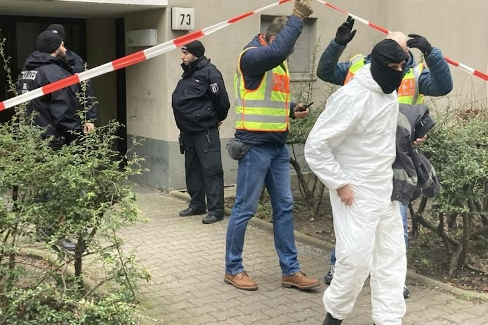 Polizisten und Kriminaltechnik vor dem Wohnhaus