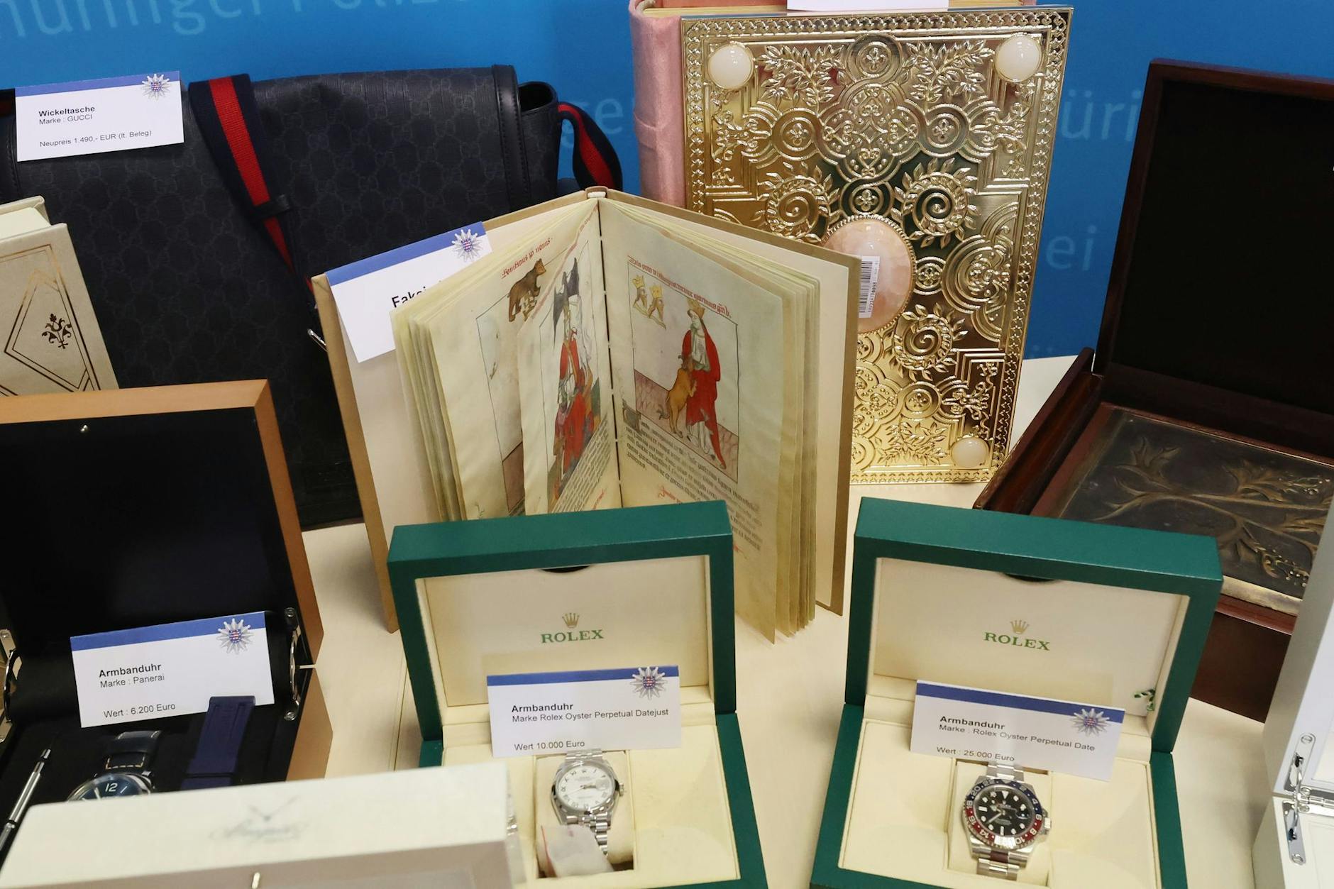 Faksimile Bücher und andere Gegenstände stehen und liegen auf einem Tisch der Kriminalpolizei.