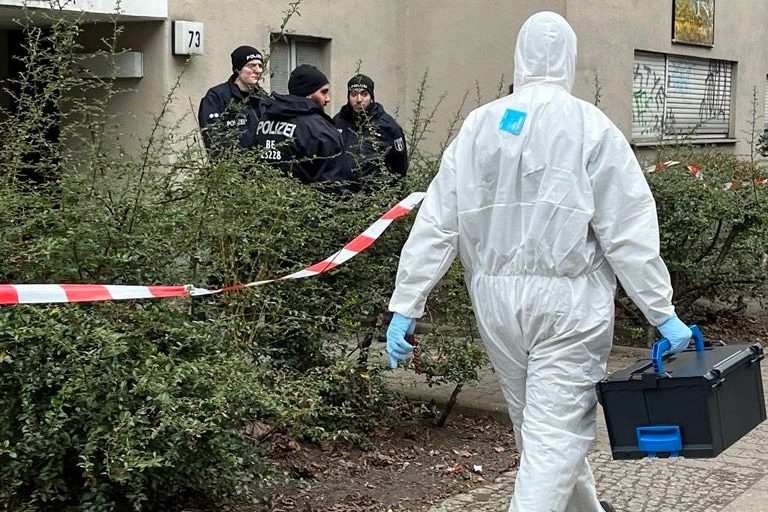 Absperrbänder flattern im Wind, Busse der Polizei stehen vor dem Eingang des Gebäudes. Polizisten stehen Wache und Techniker und Ermittler tragen Kisten aus dem Gebäude. Wer war Daniela Klette, die RAF-Terroristin, eine der meistgesuchten Personen des Landes?